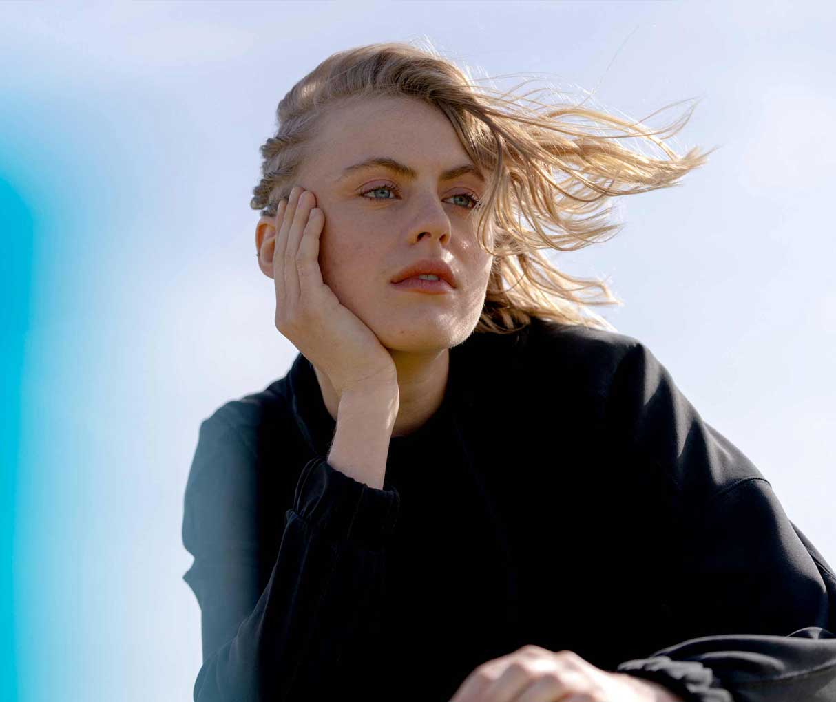 Жінка сперлася ліктем на капот автомобіля