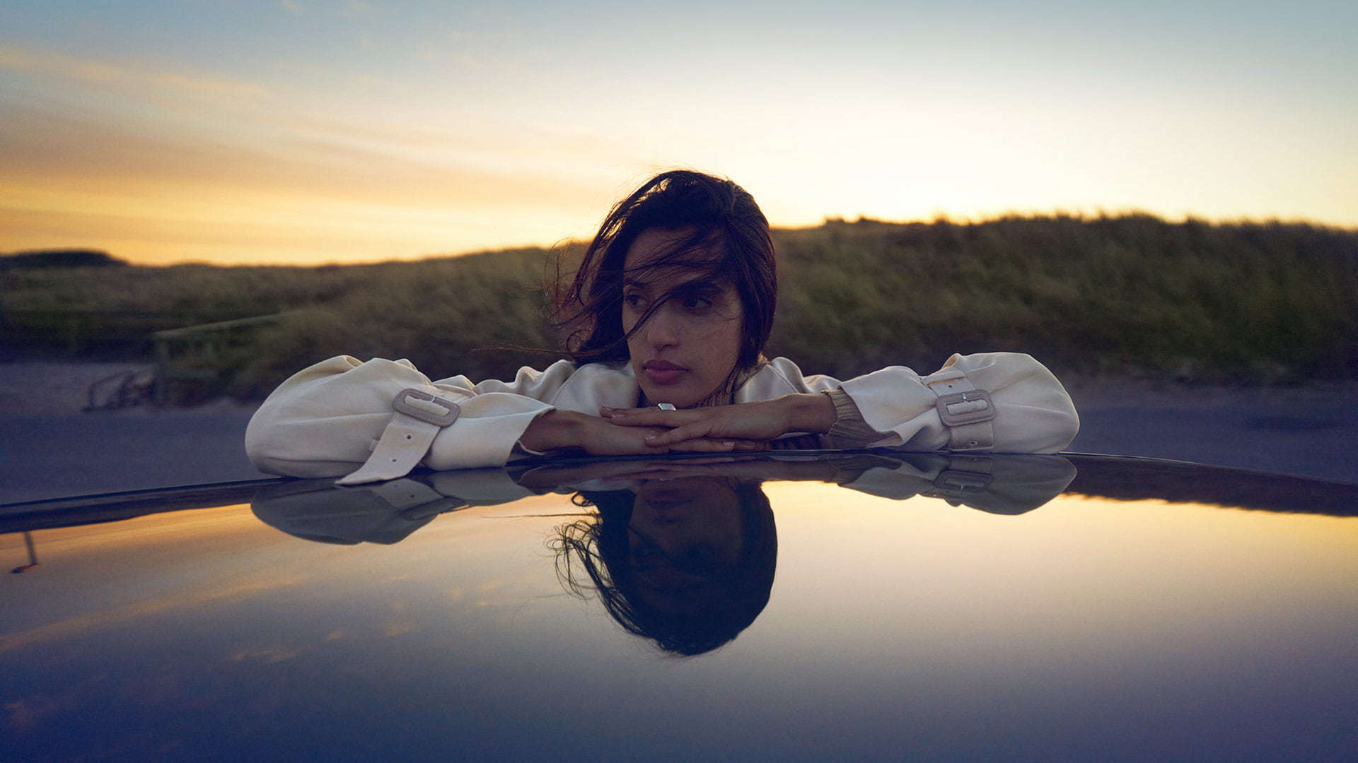 Дівчина обперлася ліктями об дах автомобіля Peugeot