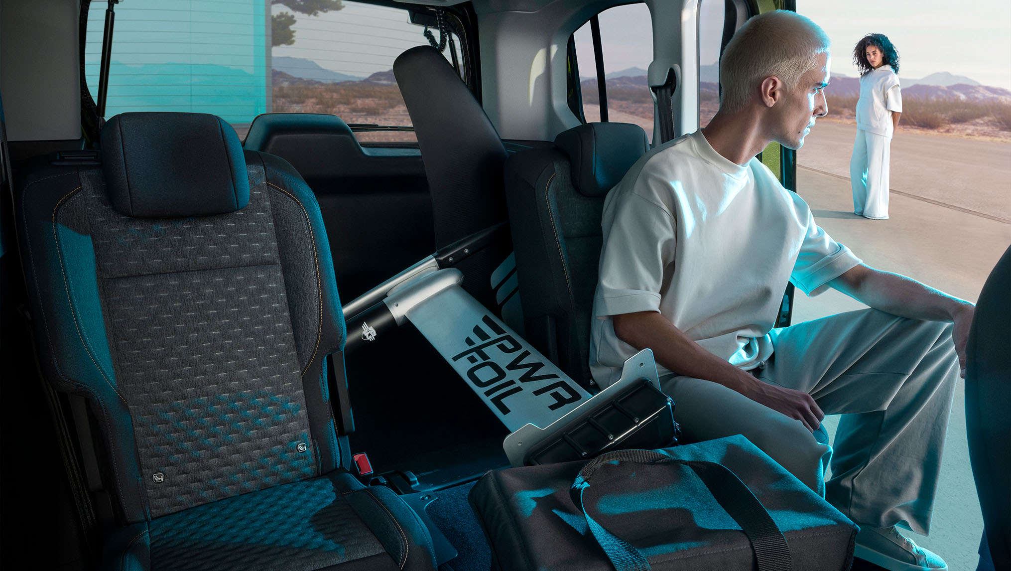 Чоловік сидить у салоні Peugeot e-Rifter разом з речами